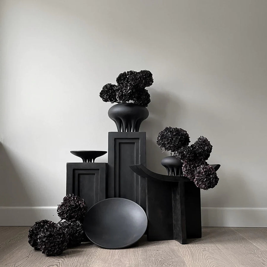A group of 101Cph Medusa Vase Big Coffee 221061 vases by 101 Copenhagen on a wooden floor.