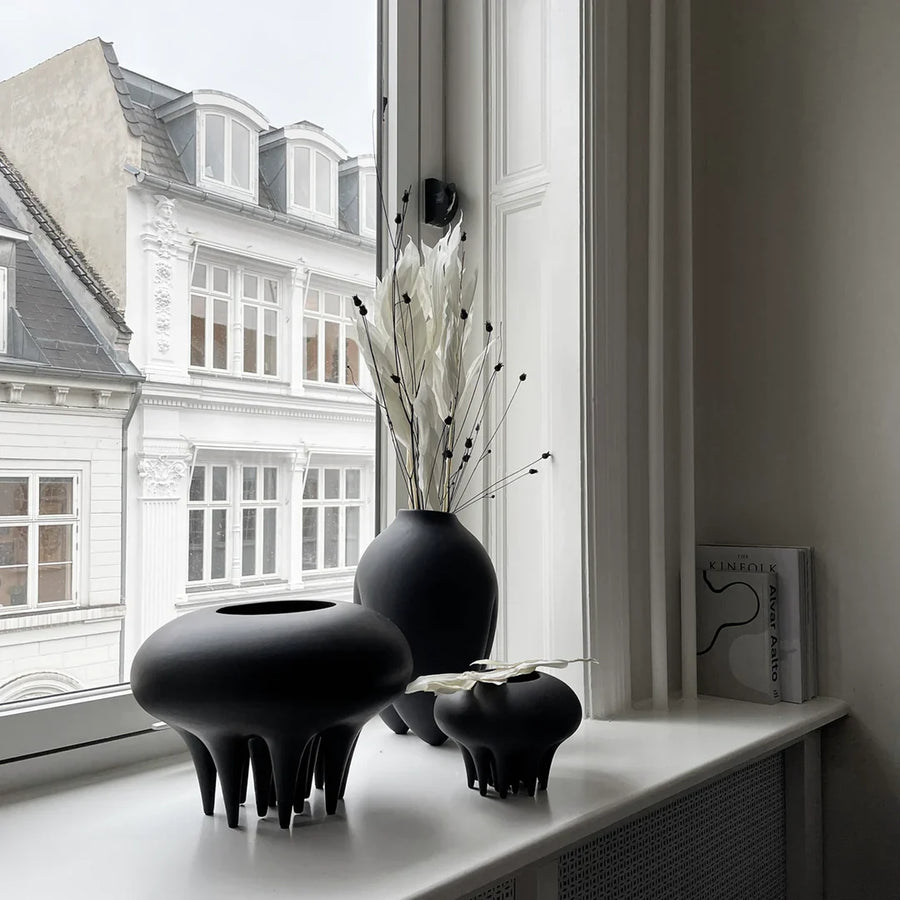 Three 101Cph Medusa Vase Big Coffee 221061 by 101 Copenhagen on a window sill.