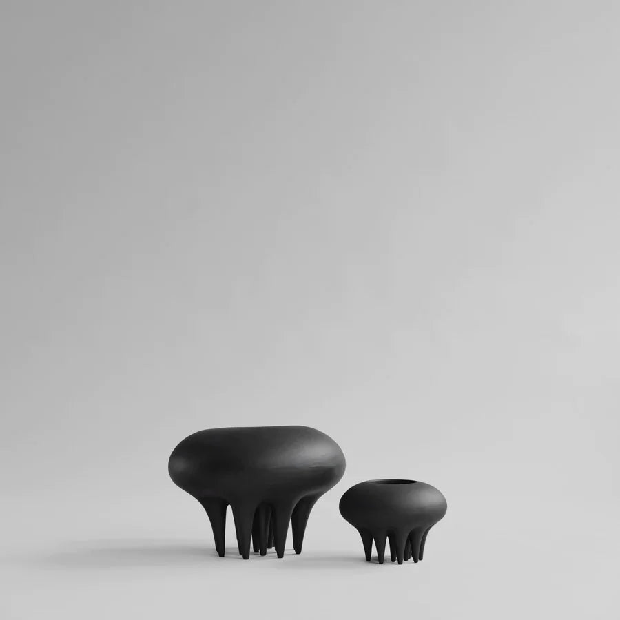 A pair of 101Cph Medusa Vase Mini Coffee 221062 ceramic stools by 101 Copenhagen on a white surface.