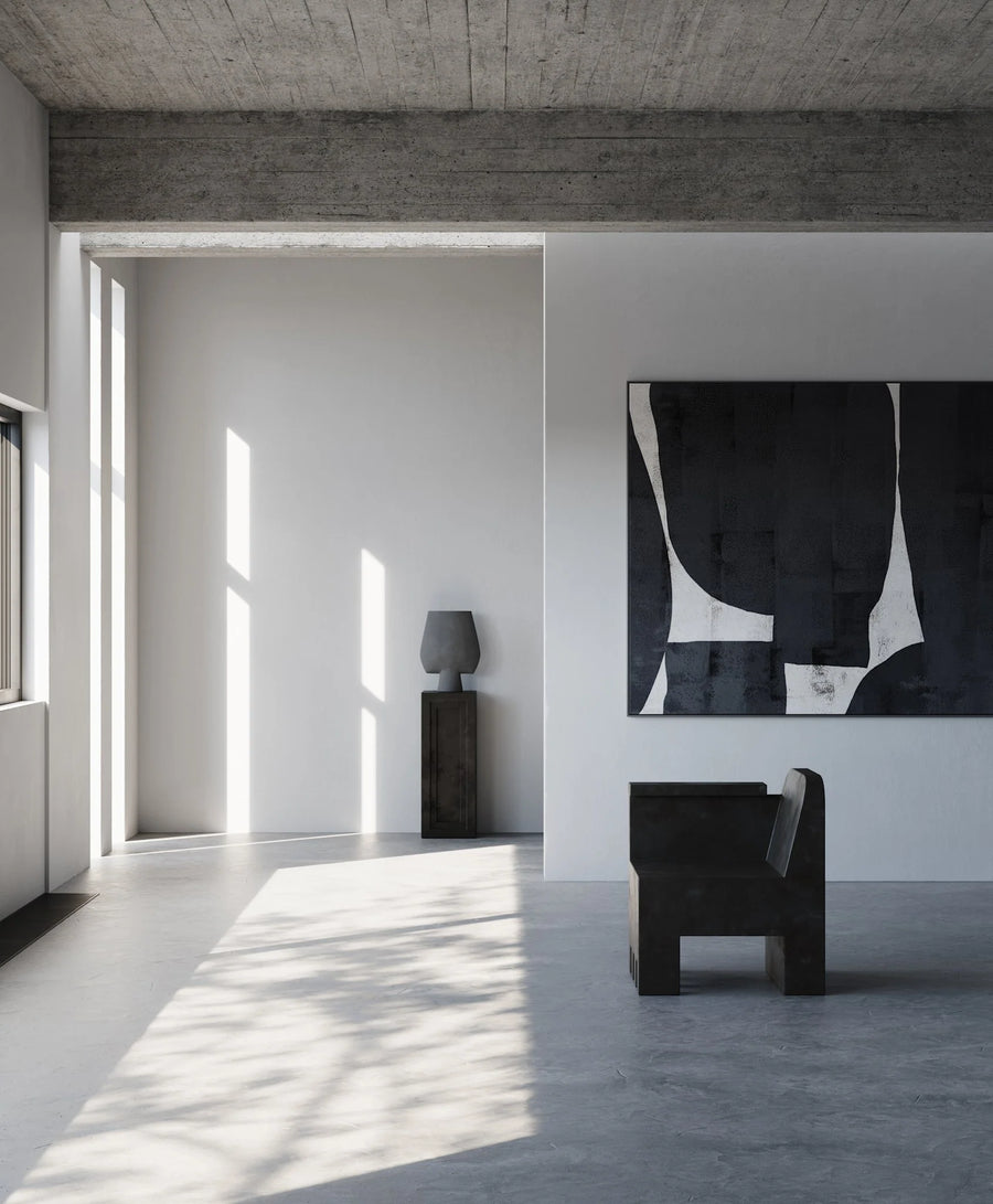 Modern interior with a black chair, abstract painting, and concrete wall and a pedestal with vase from 101 Copenhagen