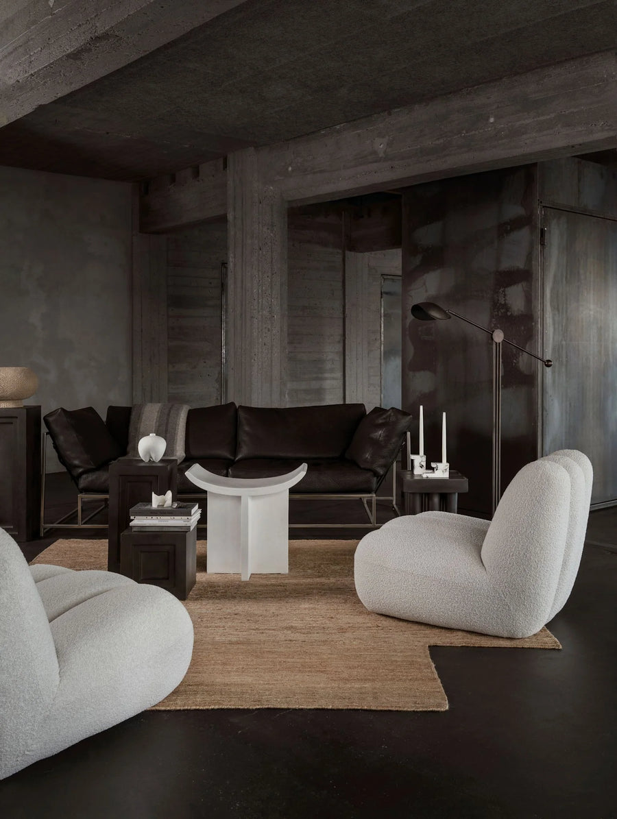 Modern living room with dark walls, a brown rug, and gray furniture.