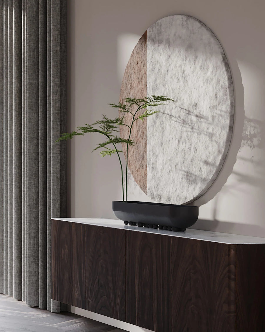 Decorative mirror with a plant in a 101 Copenhagen Shinju platter on a wooden console against a neutral wall.