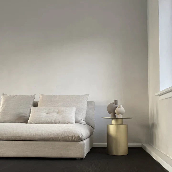 A living room with a grey 101 Copenhagen couch and a gold table featuring the 101Cph Sphere Bubl Mini Sand 203008.