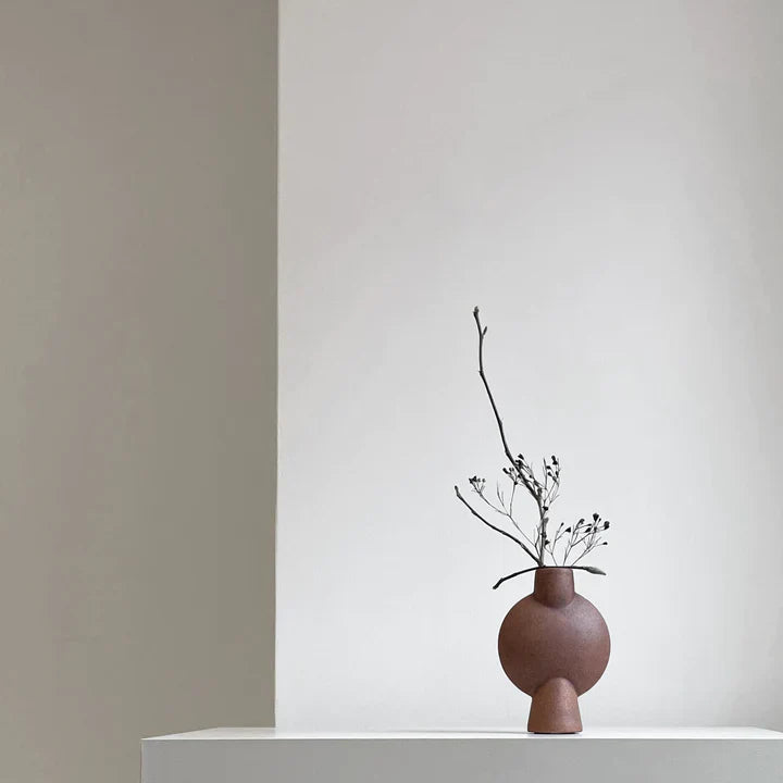 A 101Cph Sphere Bubl Mini Terracotta 203010 vase sits on a table in a white room. (Brand: 101 Copenhagen)