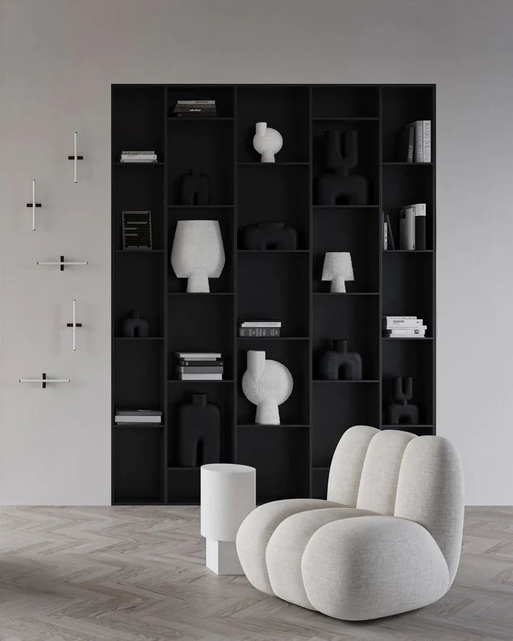 A room with a 101Cph Sphere Bubl Shisen Big B White 231013 bookcase from the brand 101 Copenhagen and a white chair, decorated in a sculptural manner.