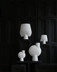 A group of 101Cph Sphere Bubl Shisen Big B White 231013 vases displayed in a decorative and sculptural manner on a black table. (Brand Name: 101 Copenhagen)