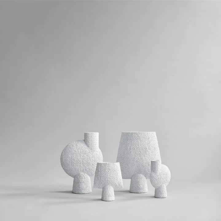 Three 101Cph Sphere Bubl Shisen Big B White 231013 vases on a grey background with a sculptural manner.