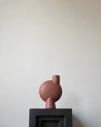 A 101Cph Sphere Vase Bubl Medio Cinnamon 221035 (Limited Edition) from 101 Copenhagen sits on top of a black box.