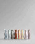 A limited edition collection of 101Cph Sphere Vase Bubl Medio Cinnamon 221035 (Limited Edition) vases in different colors, showcased on a sleek grey background by the brand 101 Copenhagen.