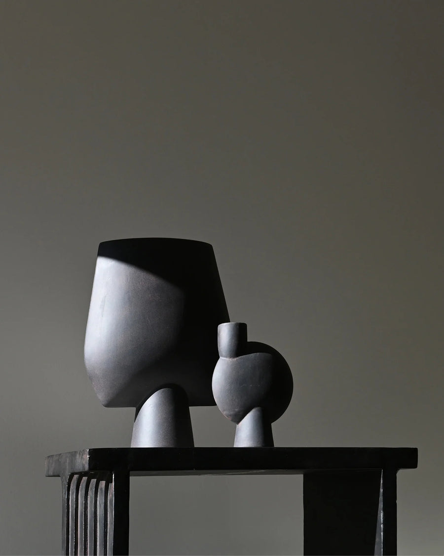 Two sculptural vase on the arc console table against a plain wall from 101 Copenhagen at Spacio retail stores in Mumbai & Kolkata. 