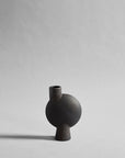 Black ceramic vase on a light gray background from 101 Copenhagen at Spacio retail stores in Mumbai & Kolkata. 