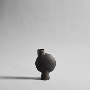 Black ceramic vase on a light gray background from 101 Copenhagen at Spacio retail stores in Mumbai & Kolkata. 