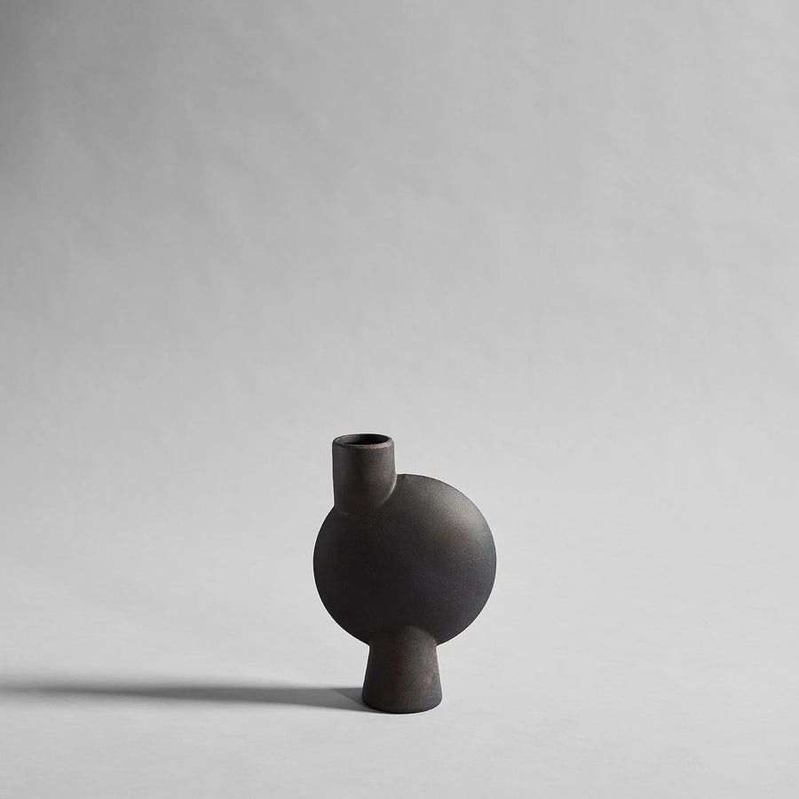 Black ceramic vase on a light gray background from 101 Copenhagen at Spacio retail stores in Mumbai & Kolkata. 