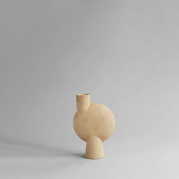Beige ceramic vase on a gray background from 101 Copenhagen at Spacio retail stores in Mumbai & Kolkata. 