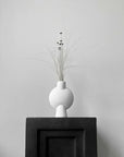 The 101Cph Sphere Vase Bubl Mini Bubble White 202003, a product by 101 Copenhagen, gracefully rests atop the sleek black box.