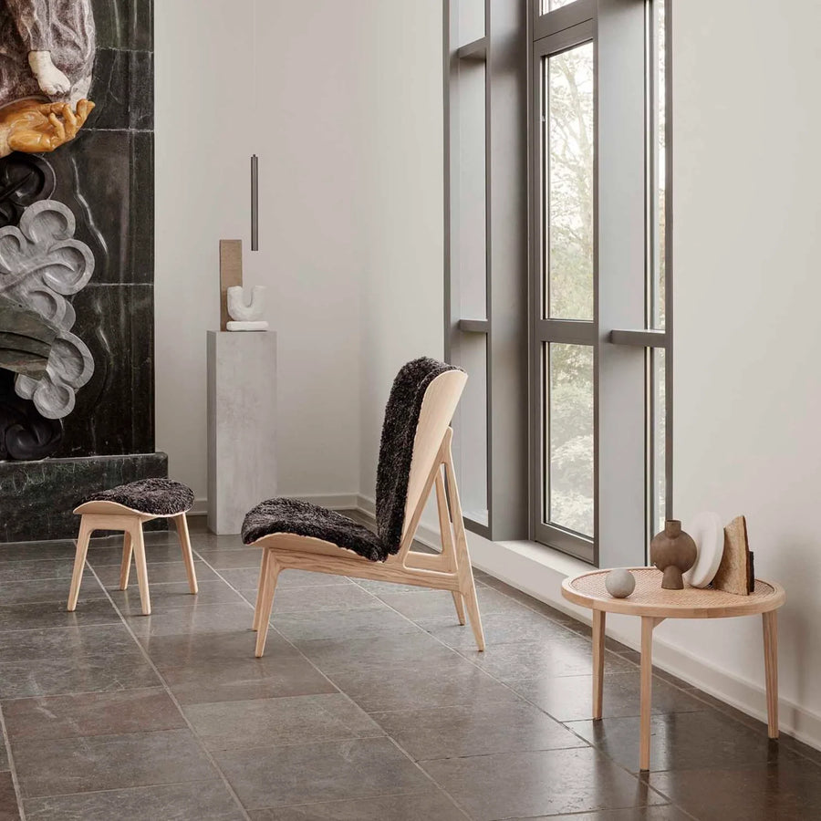 A room furnished with a wooden chair and adorned with an ochre finish, showcasing the 101Cph Sphere Vase Bubl Mini Ocher 111180 from the renowned Scandinavian brand, 101 Copenhagen.