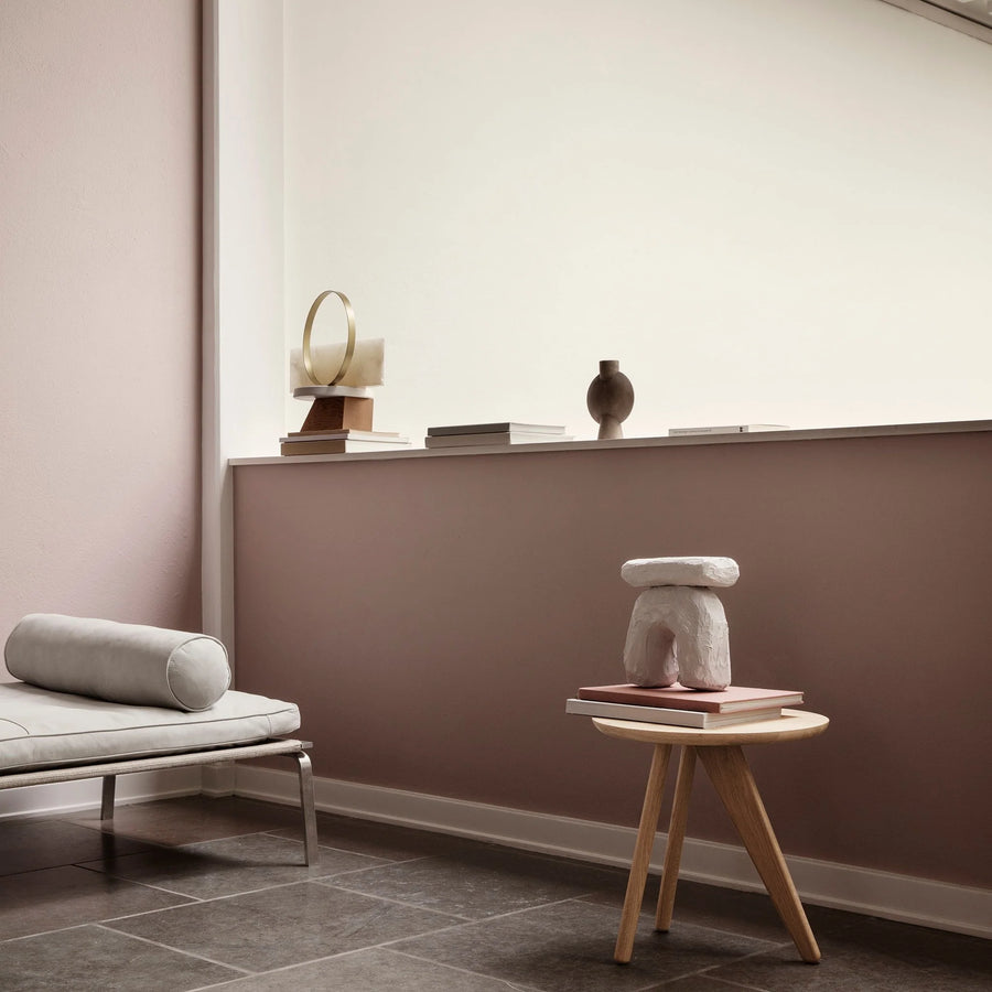 Modern interior with a white sofa, small round table, and decorative items against a wall.