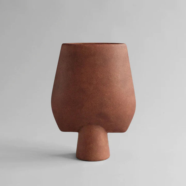 A 101Cph Sphere Vase Square Big Terracotta 212008 vase by 101 Copenhagen on a grey background.