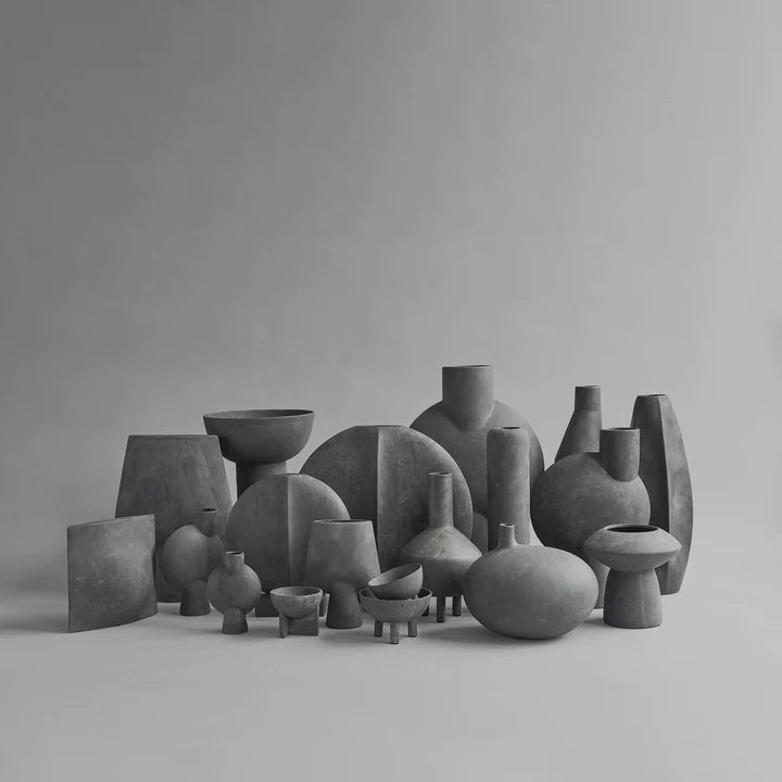 A group of 101Cph Sphere Vase Square Mini Dark Grey 111020 vases from the 101 Copenhagen Sphere collection on a grey background.