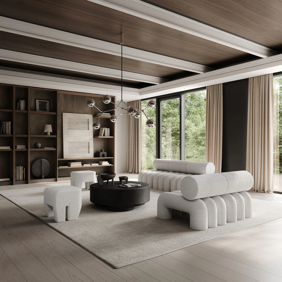Modern living room with a white sofa, coffee table, and bookshelves.