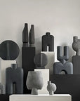 A group of black and white 101Cph Sphere Vases on a table.