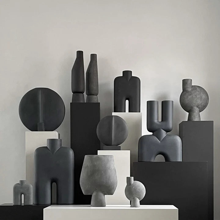 A group of black and white 101Cph Sphere Vases on a table.