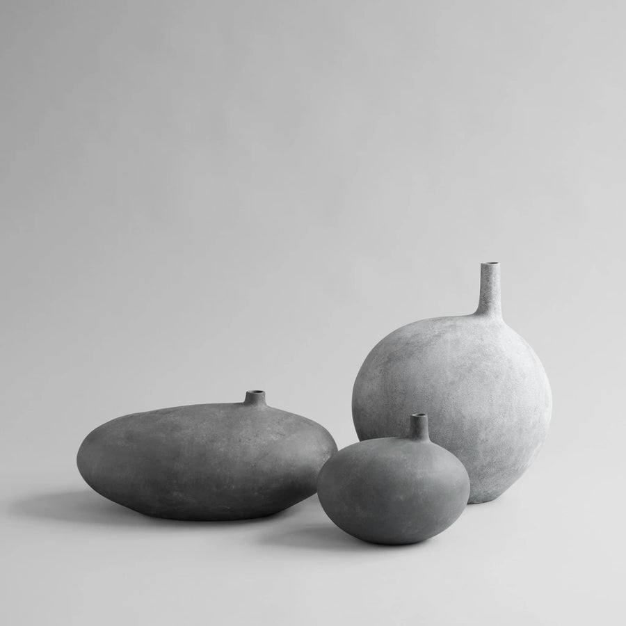 Three gray ceramic vases of different sizes on a light gray background from 101 Copenhagen at Spacio retail stores in Mumbai & Kolkata. 