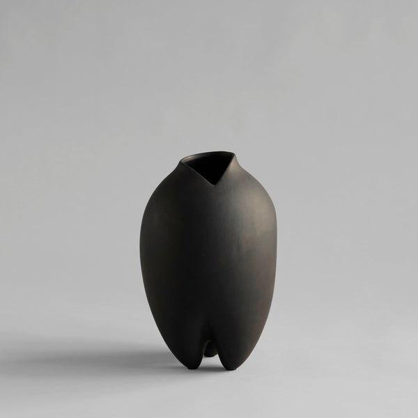 Black vase with a unique design on a gray background from 101 Copenhagen at Spacio retail stores in Mumbai & Kolkata. 