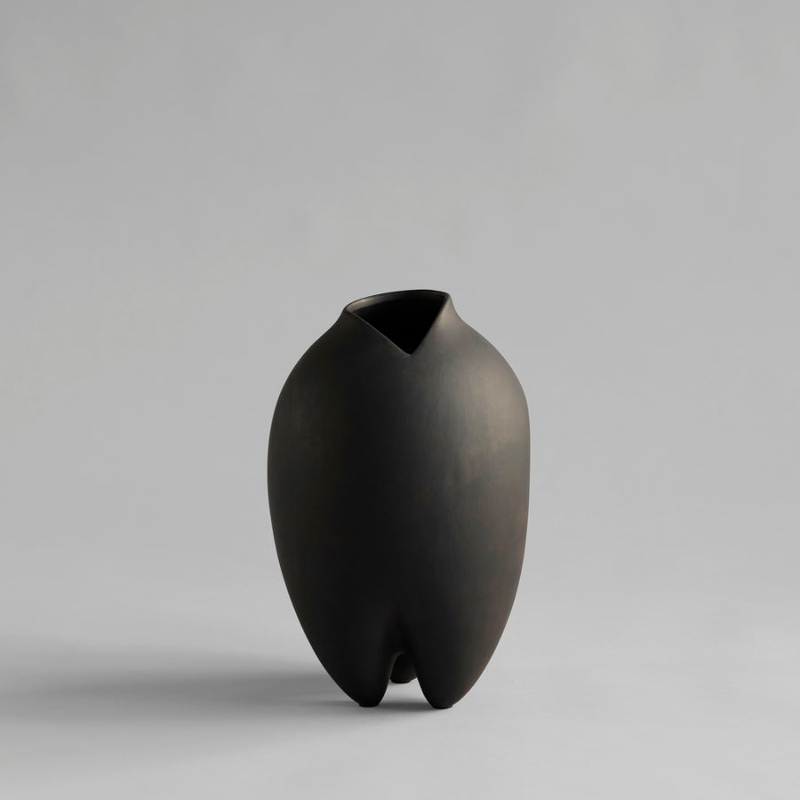 Black vase with a unique design on a gray background from 101 Copenhagen at Spacio retail stores in Mumbai & Kolkata. 