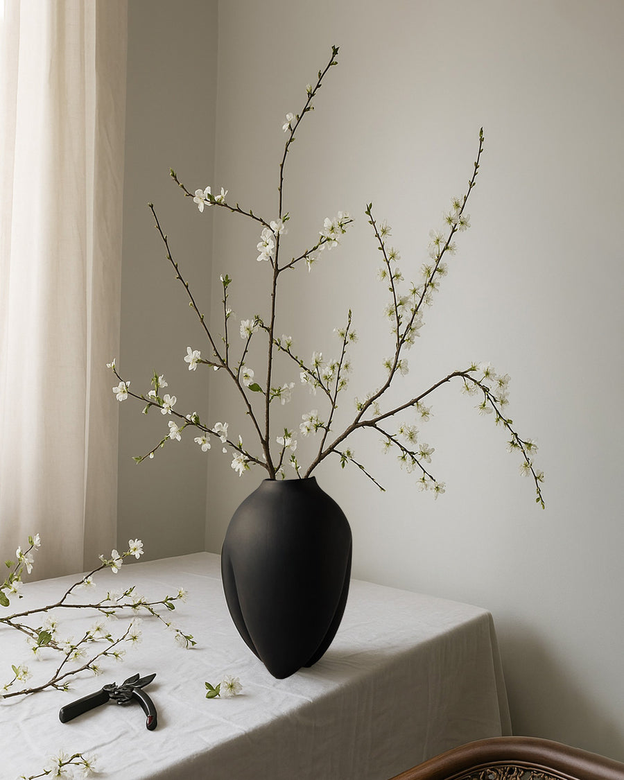 Black vase with white flowers on a tablecloth  from 101 Copenhagen at Spacio retail stores in Mumbai & Kolkata. 