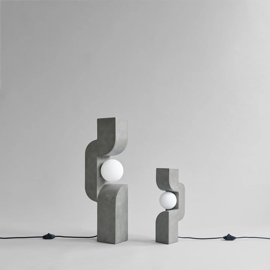 Two concrete table lamps with spherical lights on a gray background from 101 Copenhagen at Spacio retail stores in Mumbai & Kolkata. 