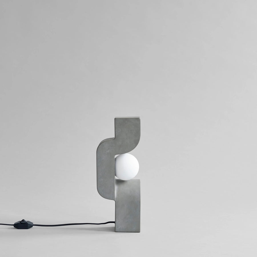 Modern wall lamp with concrete-like finish on a light gray background from 101 Copenhagen at Spacio retail stores in Mumbai & Kolkata. 