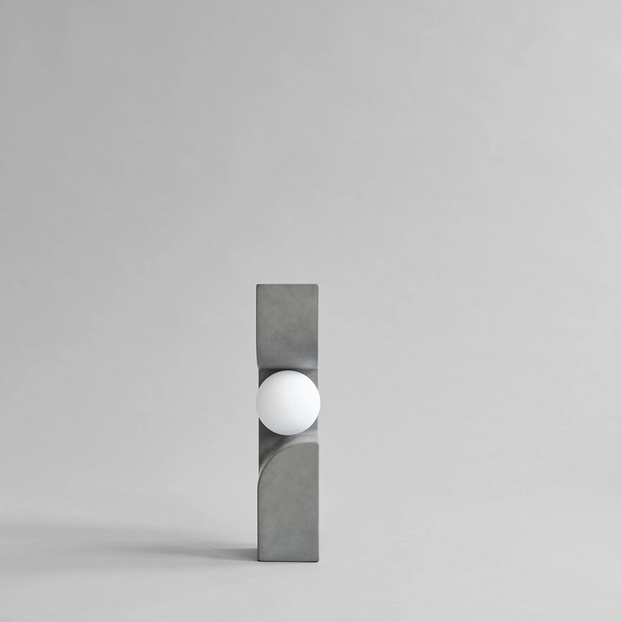 Modern wall light fixture with concrete-like finish on a gray background from 101 Copenhagen at Spacio retail stores in Mumbai & Kolkata. 