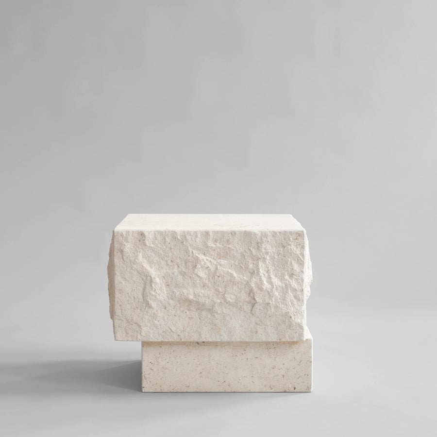 Side view of a rectangular limestone plinth on a gray background from 101 Copenhagen at Spacio retail stores in Mumbai & Kolkata. 