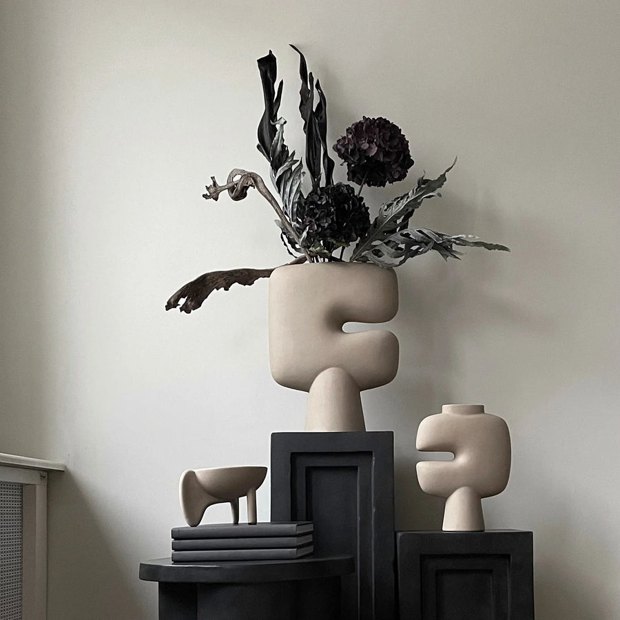 Decorative sculptural vase with dried plants on podiums (plinths/ pedestals) against a neutral wall from 101 Copenhagen at Spacio retail stores in Mumbai & Kolkata.