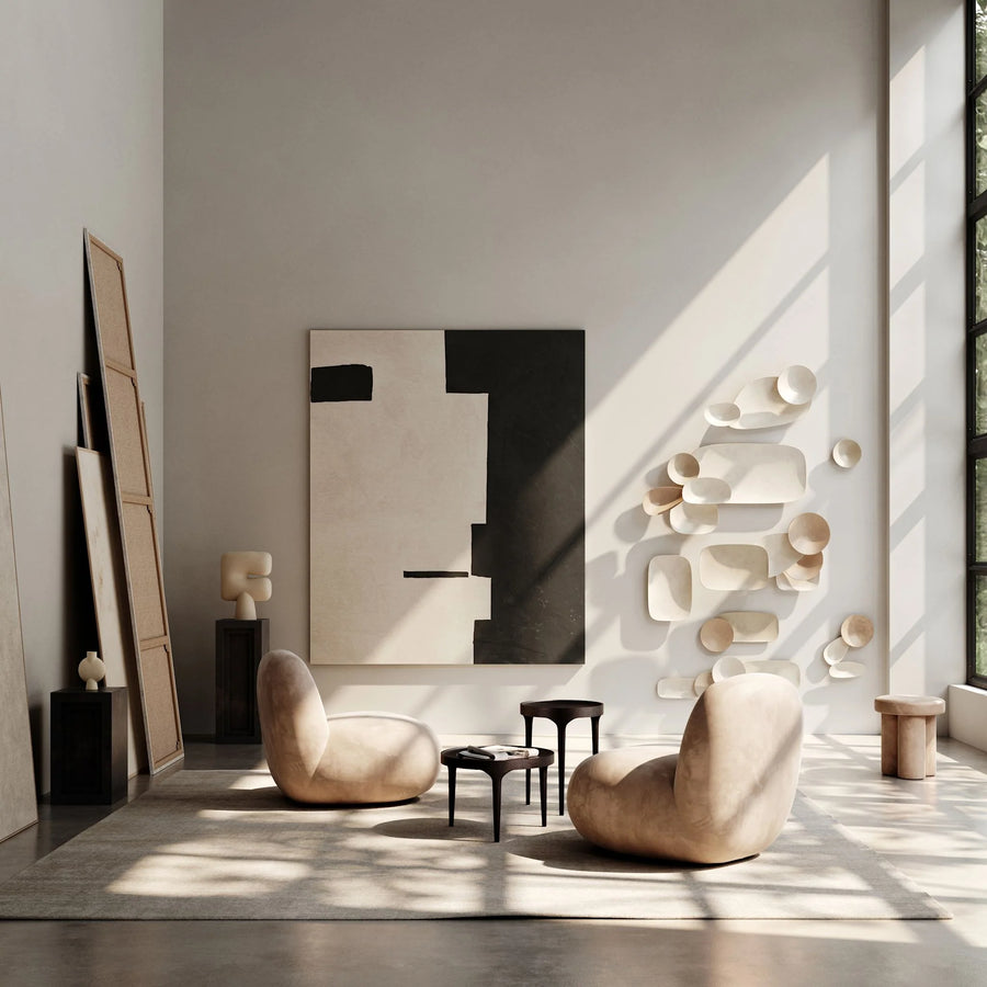 Modern interior with two beige chairs, a abstract painting, and decorative wall pieces.