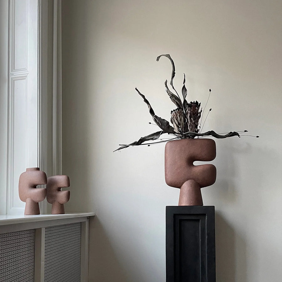 Decorative vase from 101 Copenhagen with abstract design on a shelf against a neutral wall