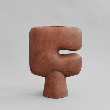 Brown sculptural vase on a gray background from 101 Copenhagen at Spacio retail stores in Mumbai & Kolkata. 