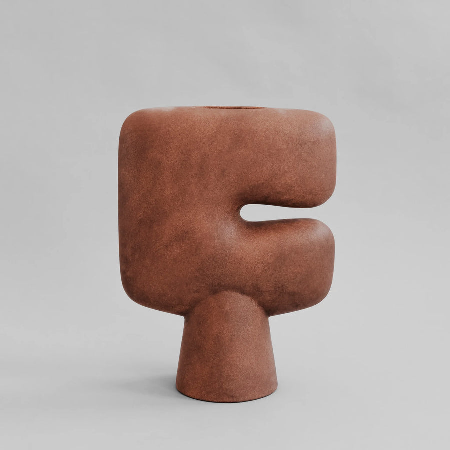 Brown sculptural vase on a gray background from 101 Copenhagen at Spacio retail stores in Mumbai & Kolkata. 
