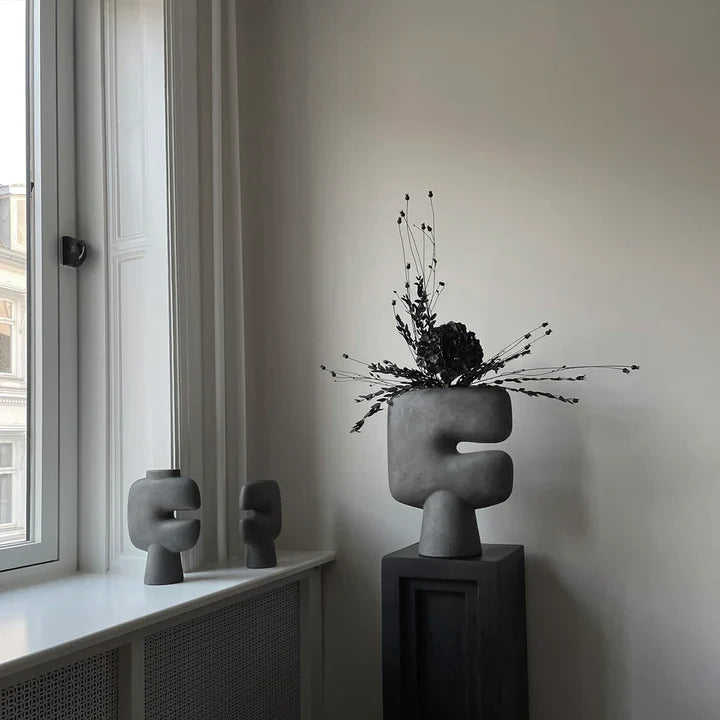 A room with two 101Cph Tribal Vase Medio Dark Grey 214003 by 101 Copenhagen in front of a window. Available at Spacio India