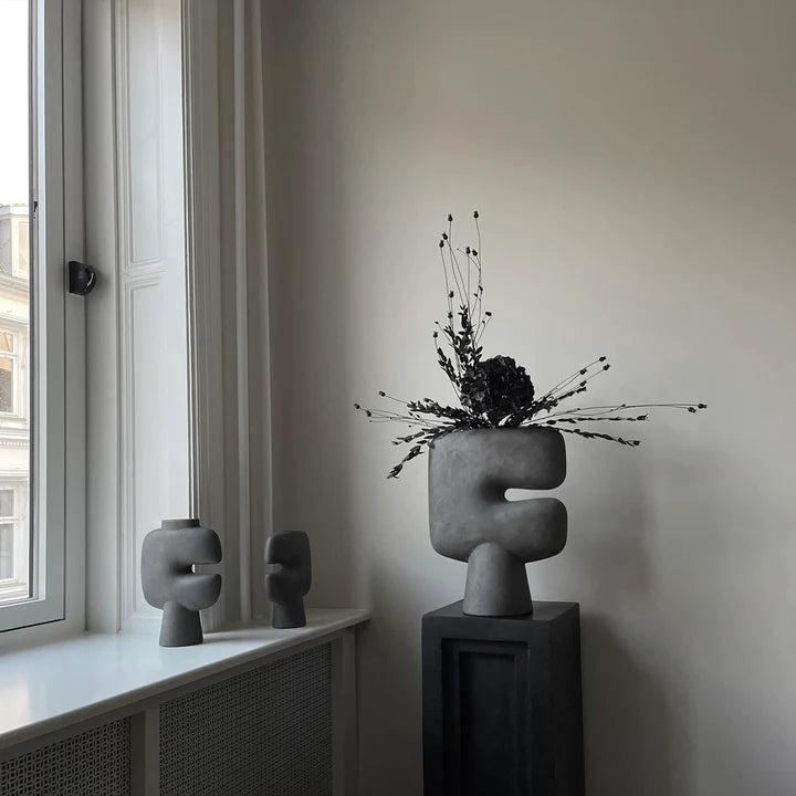 A room with two 101Cph Tribal Vase Medio Dark Grey 214003 by 101 Copenhagen in front of a window.  Available at Spacio India
