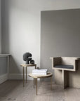 A dark grey room with a chair and a table, featuring a 101Cph Tribal Vase Medio Dark Grey 214003 from the 101 Copenhagen tribal collection. Available at Spacio India