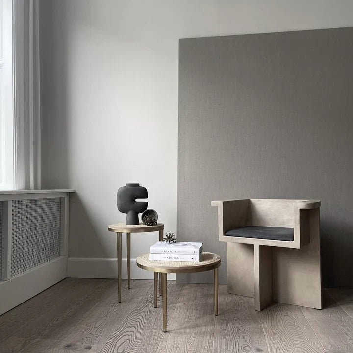 A dark grey room with a chair and a table, featuring a 101Cph Tribal Vase Medio Dark Grey 214003 from the 101 Copenhagen tribal collection. Available at Spacio India