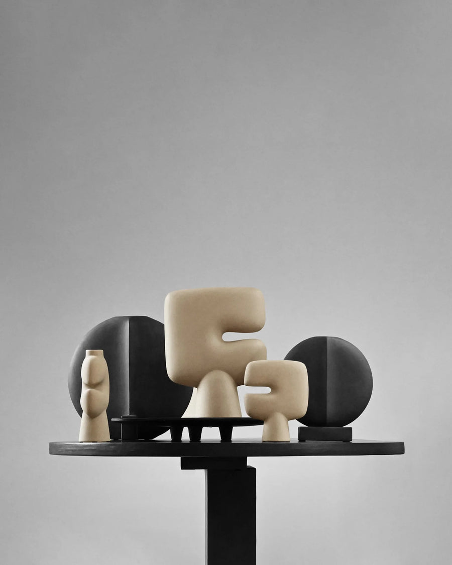 Decorative sculptures on a stand against a gray background from 101 Copenhagen at Spacio retail stores in Mumbai & Kolkata. 