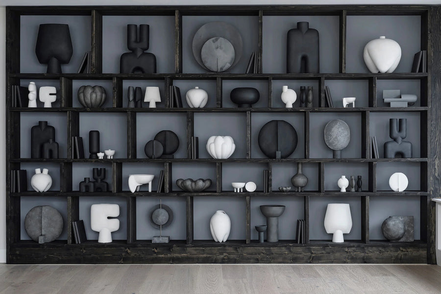 Wall with black shelving unit displaying various black and white ceramic sculptures from 101 Copenhagen at Spacio retail stores in Mumbai & Kolkata. 