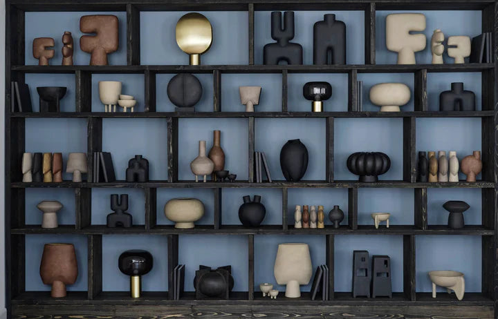 A shelf showcasing a diverse collection of 101Cph Tribal Vase Minis in various hues, including the earthy Sand color, from the exquisite 101 Copenhagen Tribal Collection. Available at Spacio India