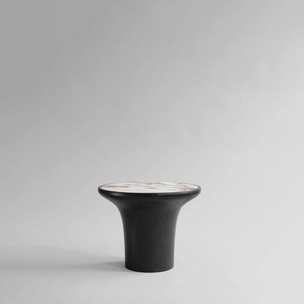 Black ceramic side table with white calacatta marble top on a gray background from 101 Copenhagen at Spacio retail stores in Mumbai & Kolkata. 