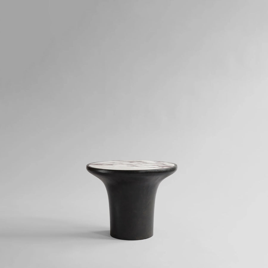 Black ceramic side table with white calacatta marble top on a gray background from 101 Copenhagen at Spacio retail stores in Mumbai & Kolkata. 