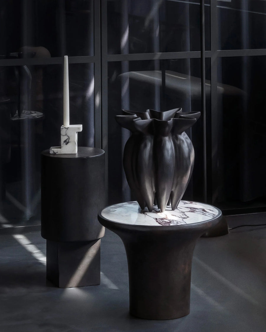 Dark vase on a calacatta marble top side table with a blurred background from 101 Copenhagen at Spacio retail stores in Mumbai & Kolkata. 