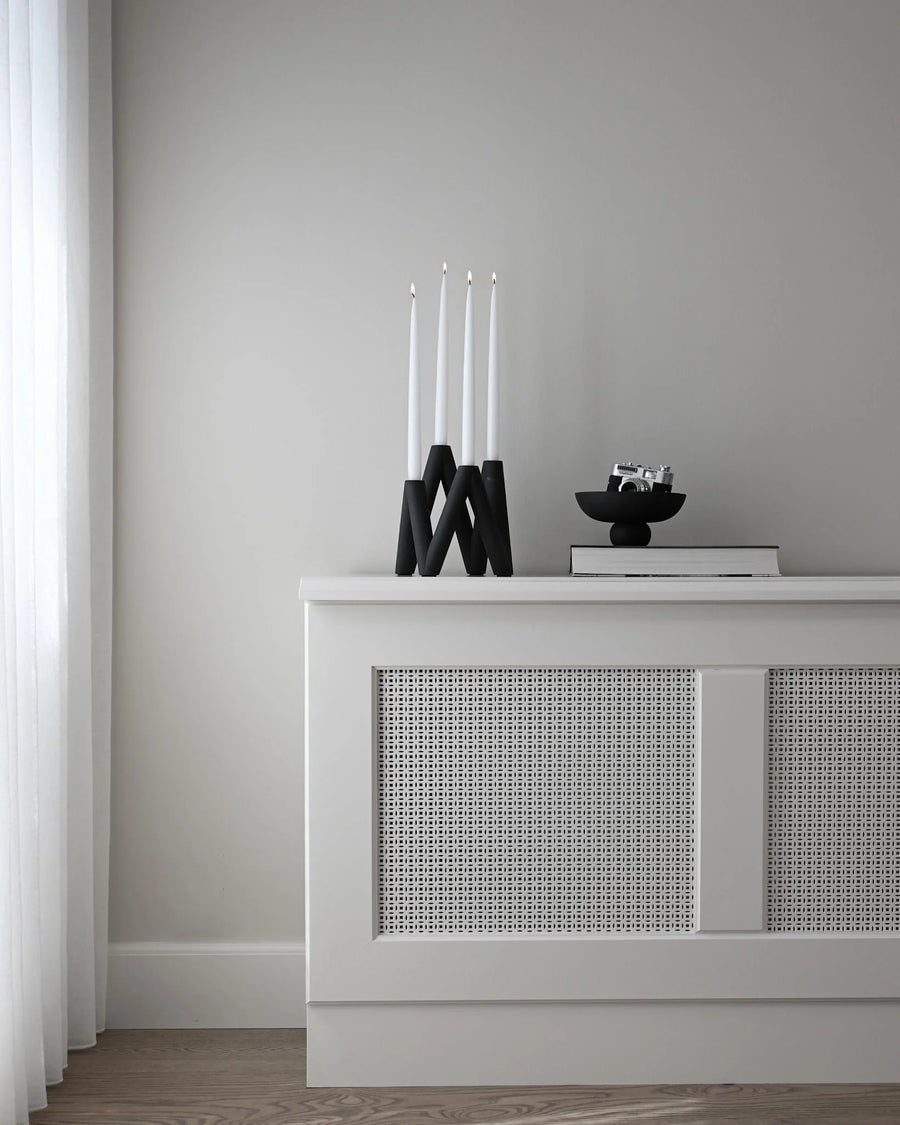 White console table with decorative items against a gray wall from 101 Copenhagen at Spacio retail stores in Mumbai & Kolkata. 